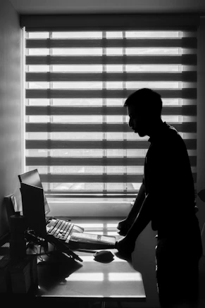 A man standing in front of a computer in a room