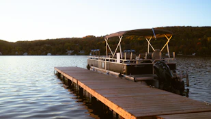 A boat docked at a pier on a lake