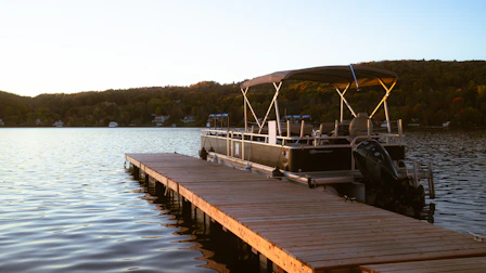 A boat docked at a pier on a lake