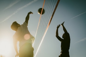 A couple of men playing a game of volleyball