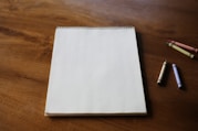 A notepad and some crayons on a table