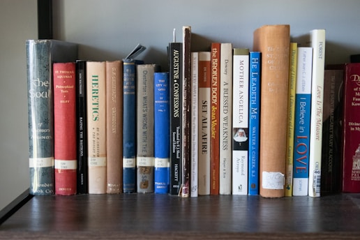 A bookshelf filled with lots of books on top of a wooden table