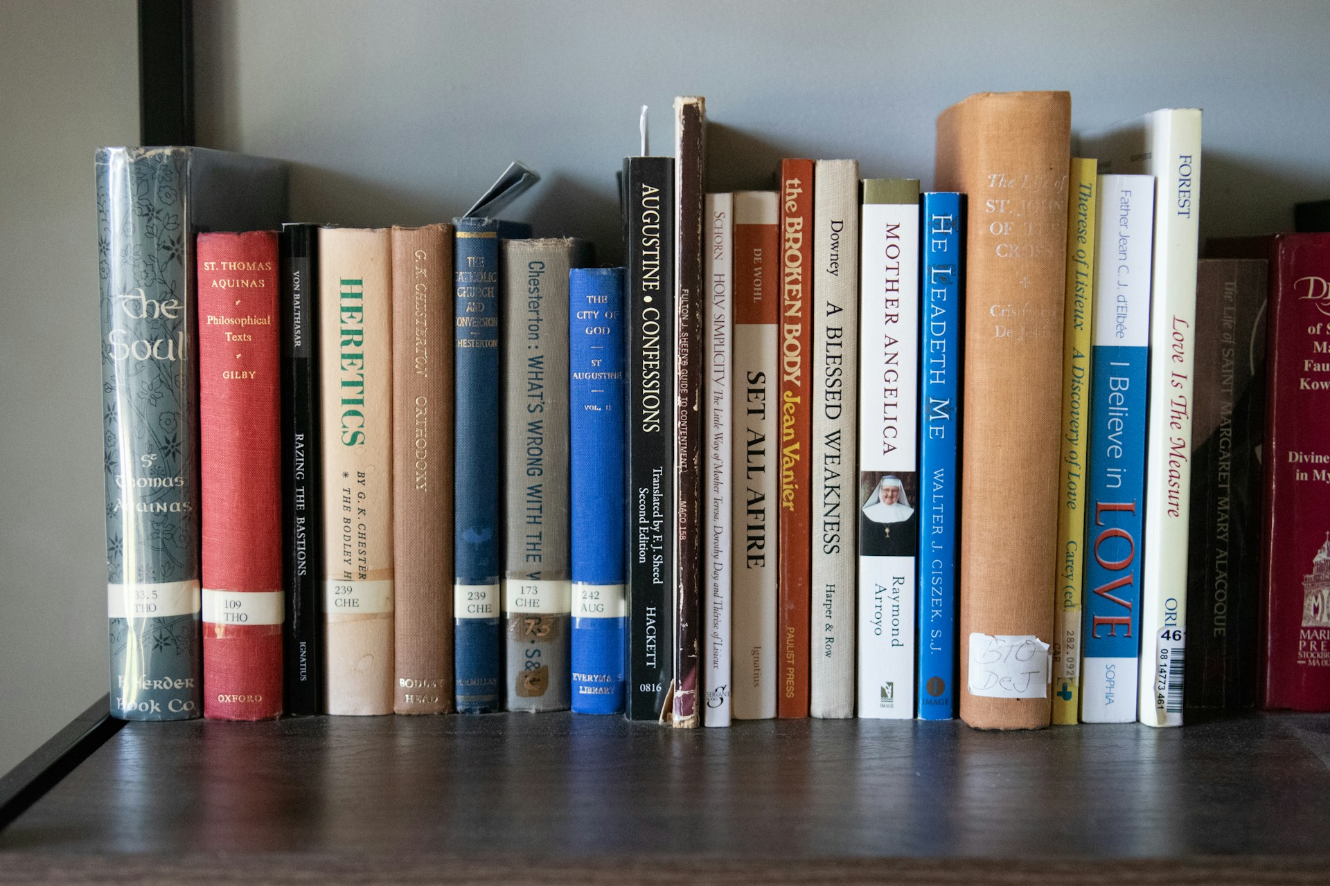 A bookshelf filled with lots of books on top of a wooden table