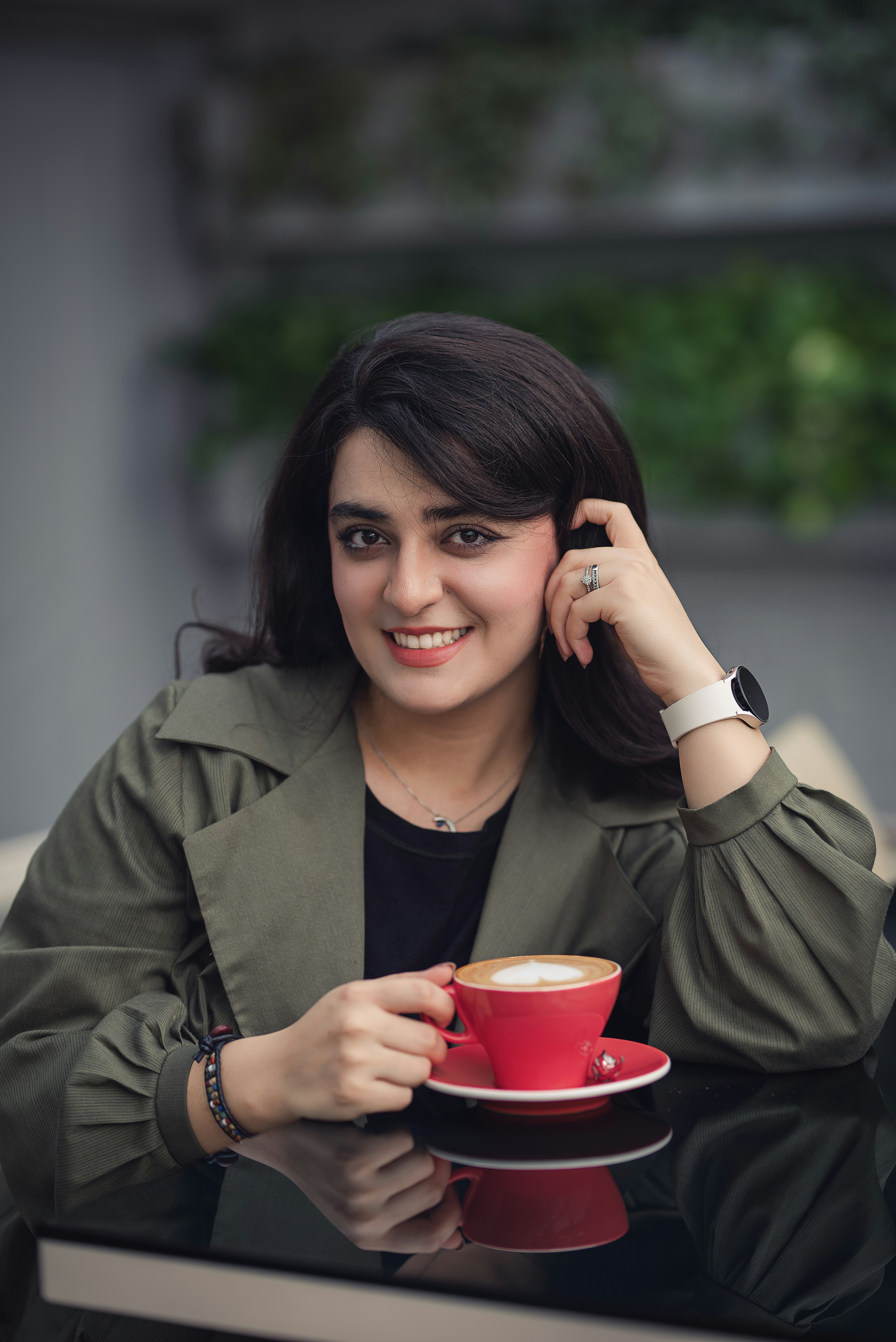 A woman sitting at a table with a cup of coffee