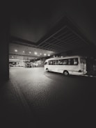 A bus parked in a parking lot at night