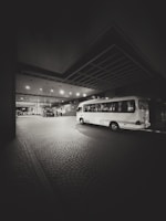 A bus parked in a parking lot at night