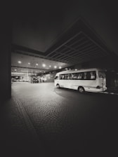 A bus parked in a parking lot at night