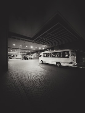 A bus parked in a parking lot at night