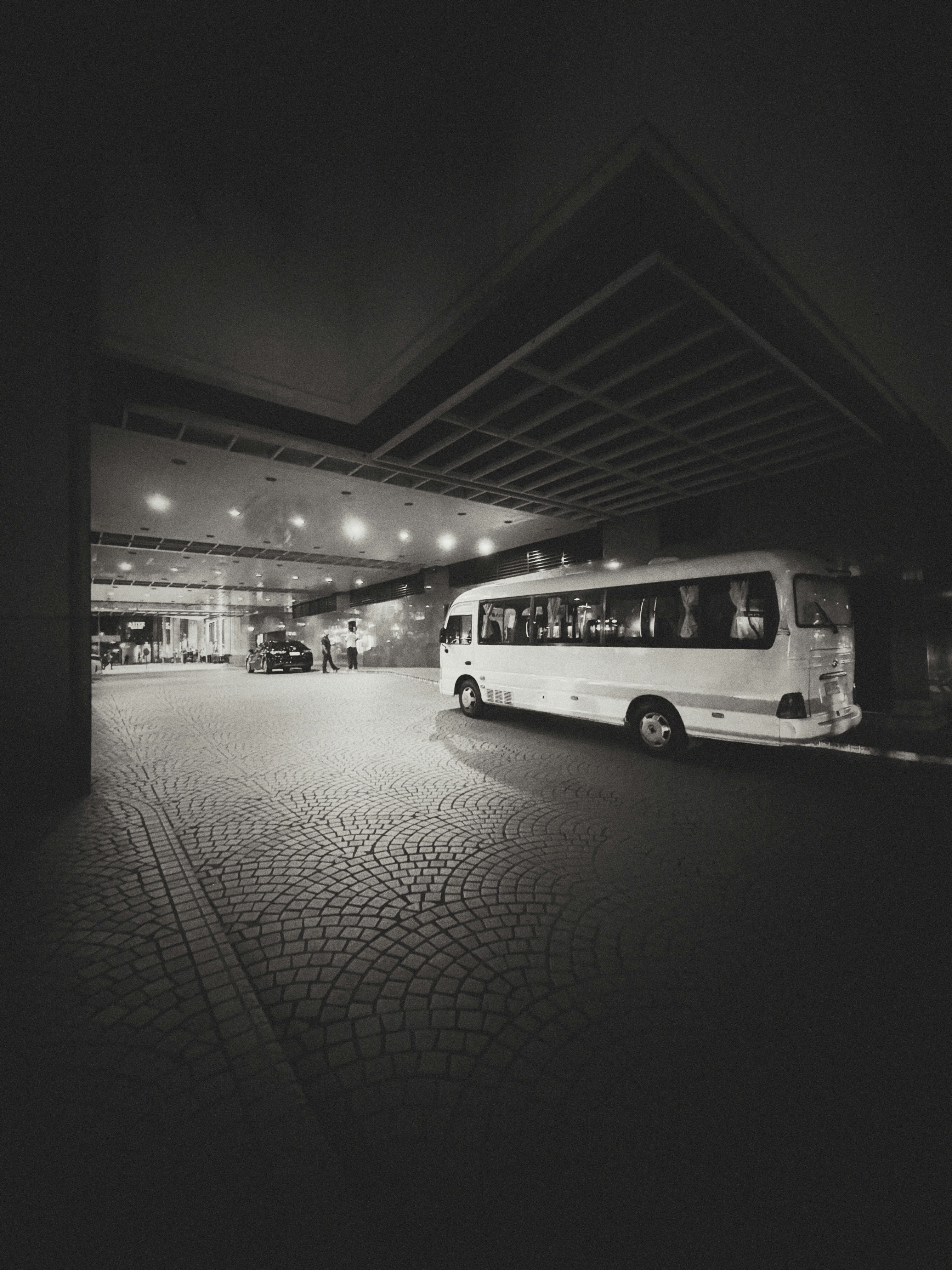 A bus parked in a parking lot at night