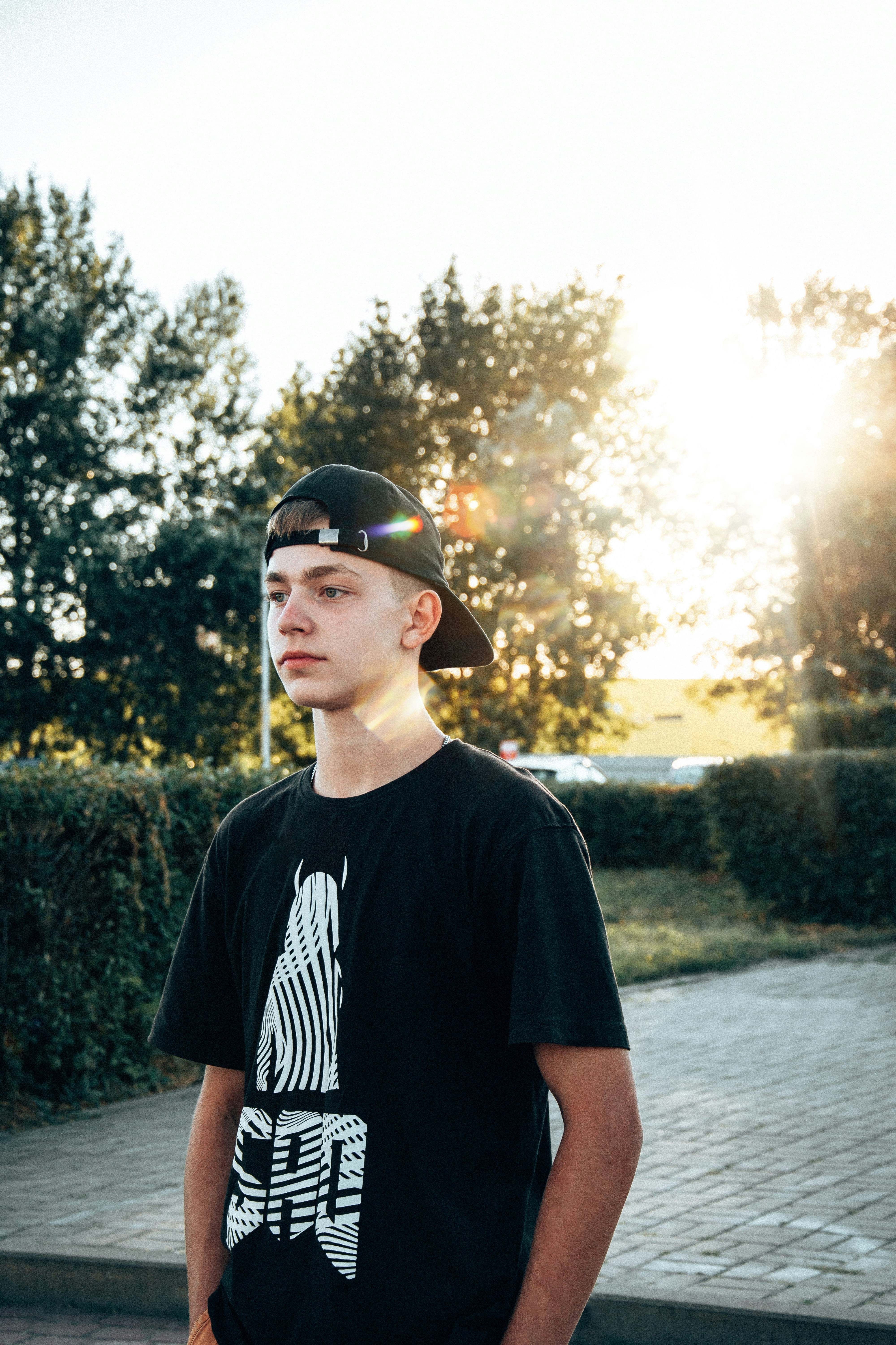 A young man wearing a black hat and a black t - shirt