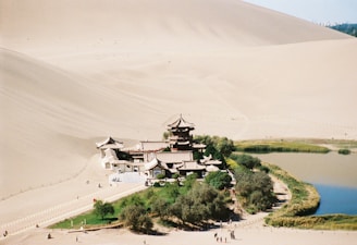 A group of people standing on top of a sandy hill