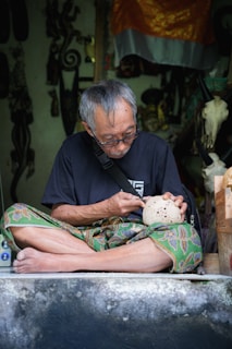 A man sitting on the ground with a bowl in his hand