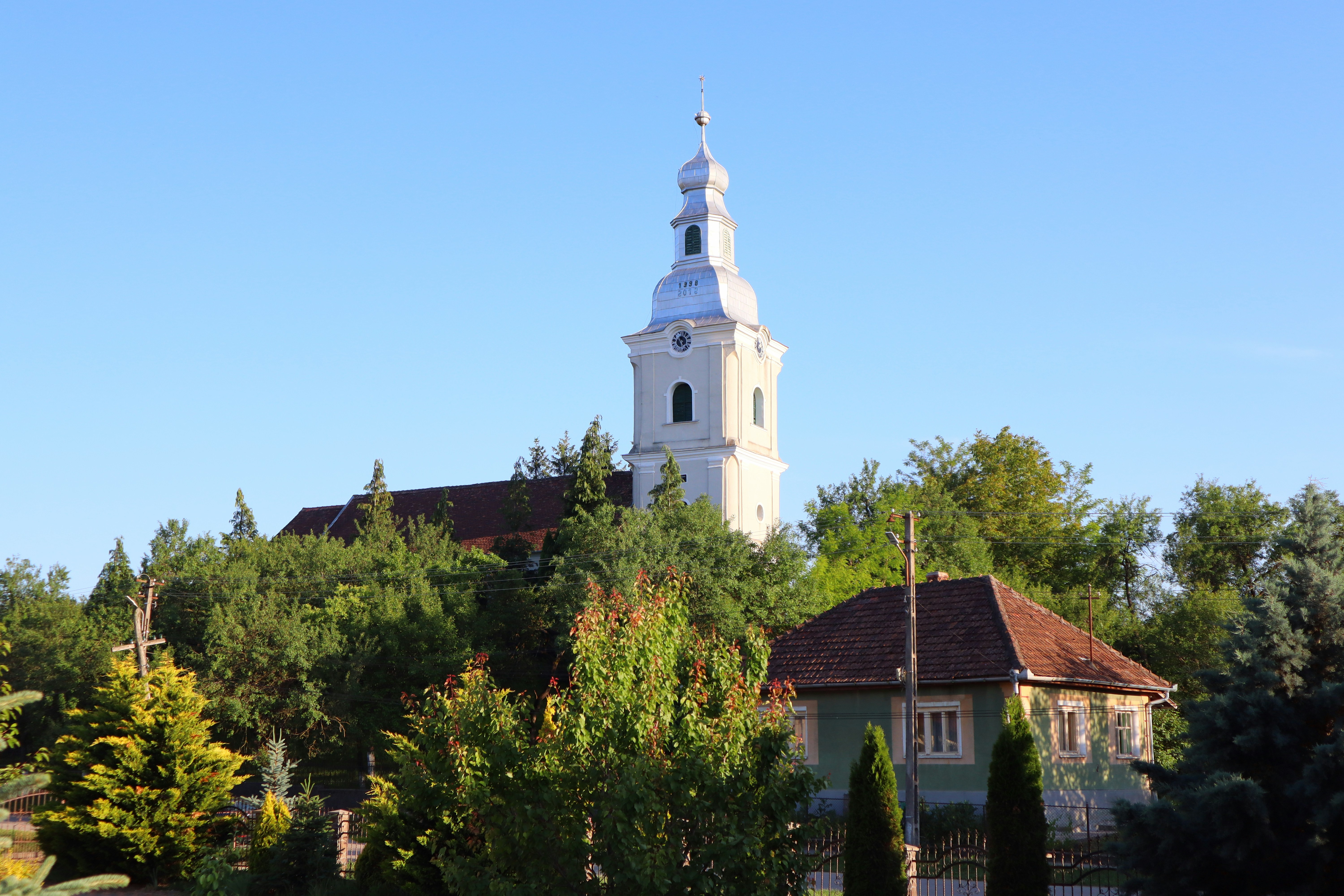 A white church with a steeple on a clear day