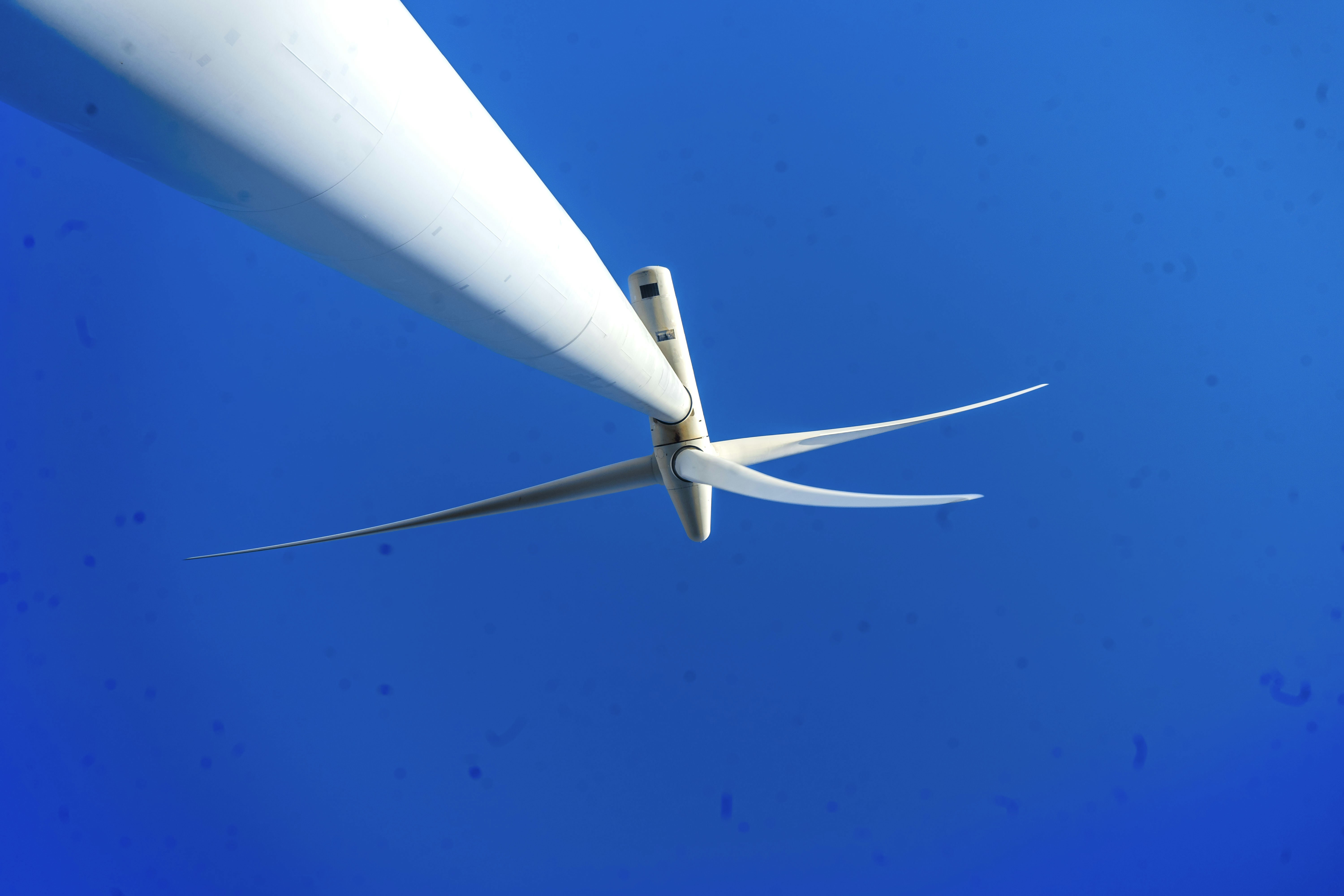 A large white object flying through a blue sky