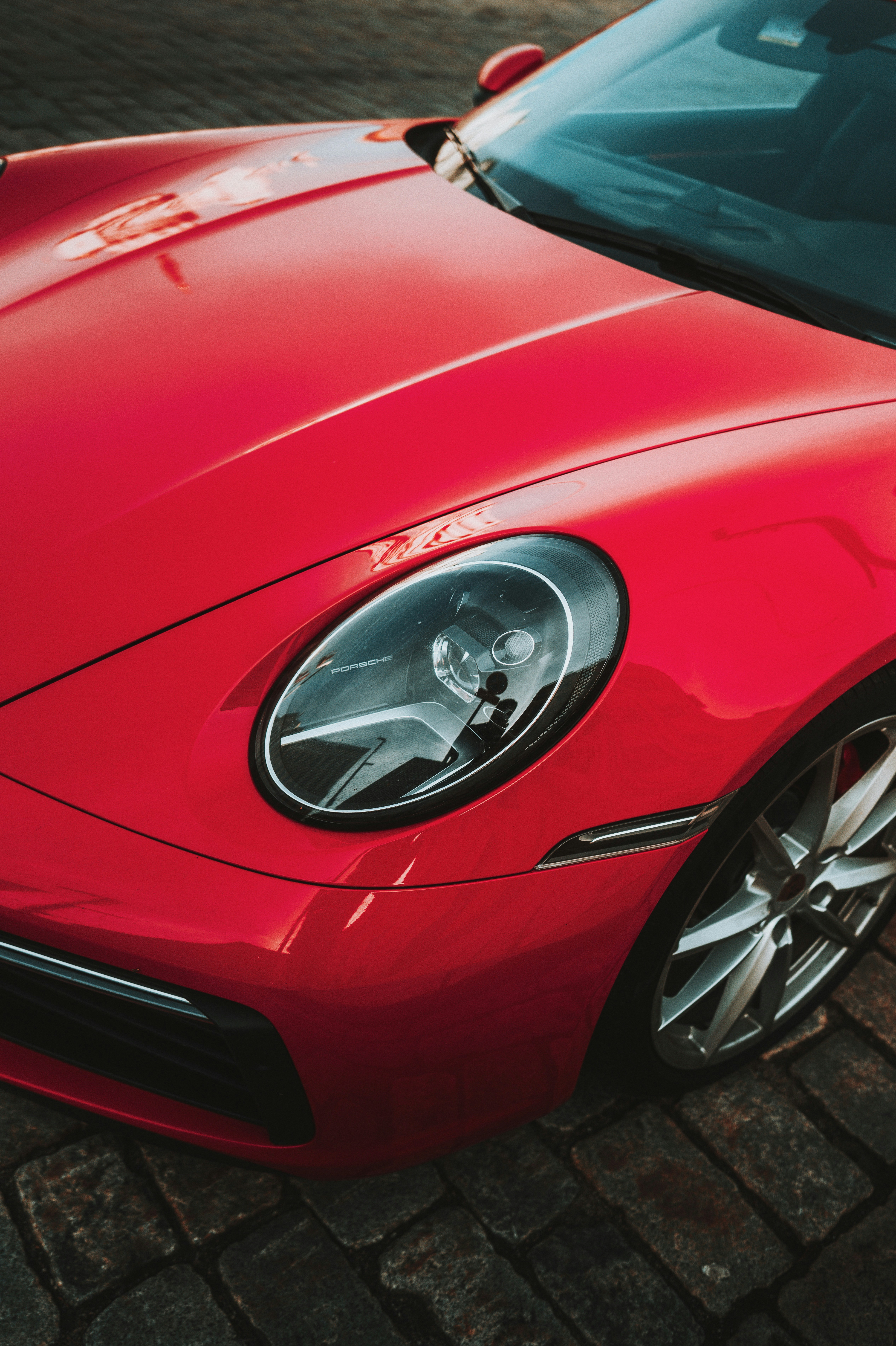 レンガ造りの道路に停まった赤いスポーツカー