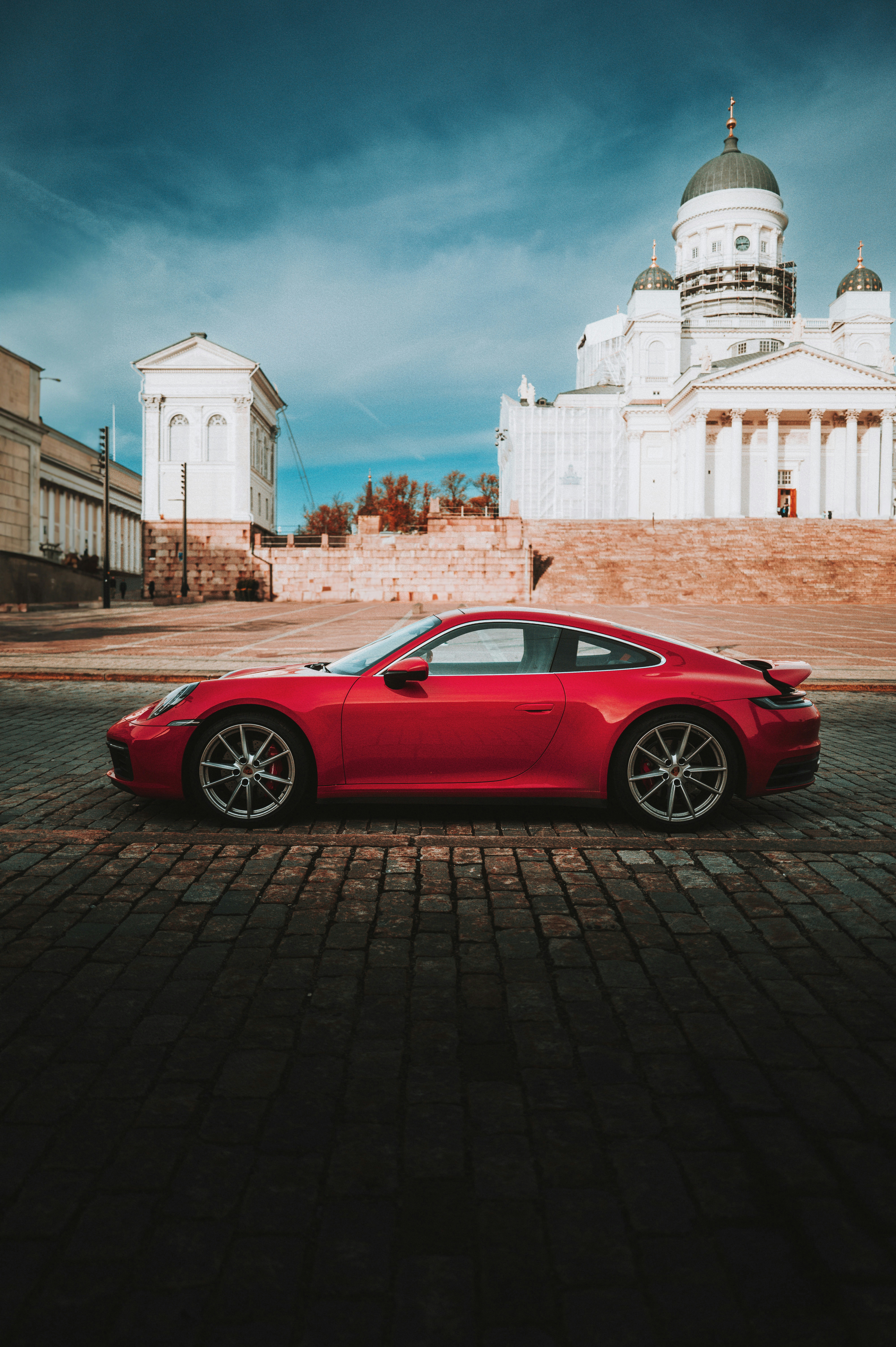 建物の前に停まっている赤いスポーツカー