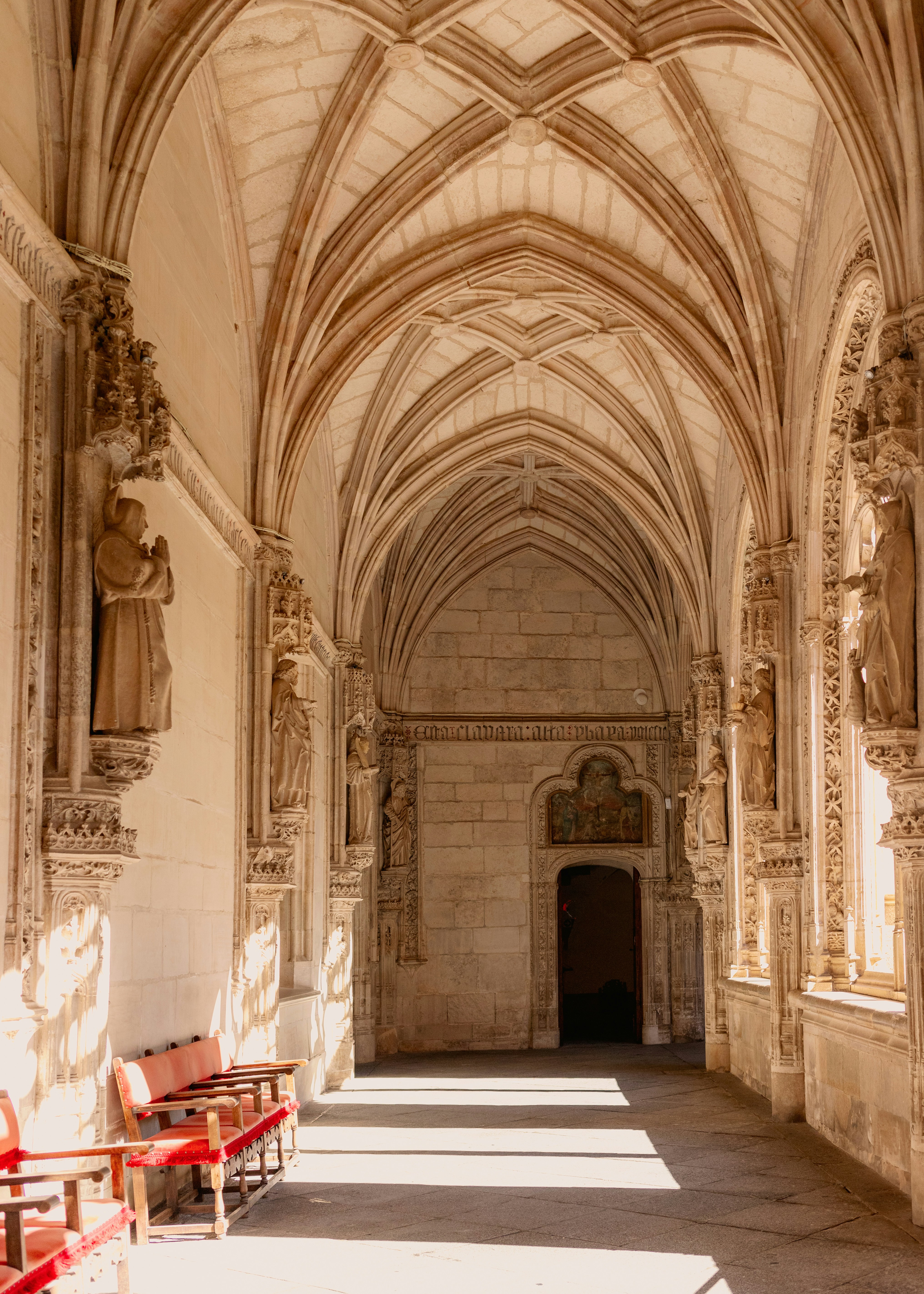 A long hallway with red chairs in it