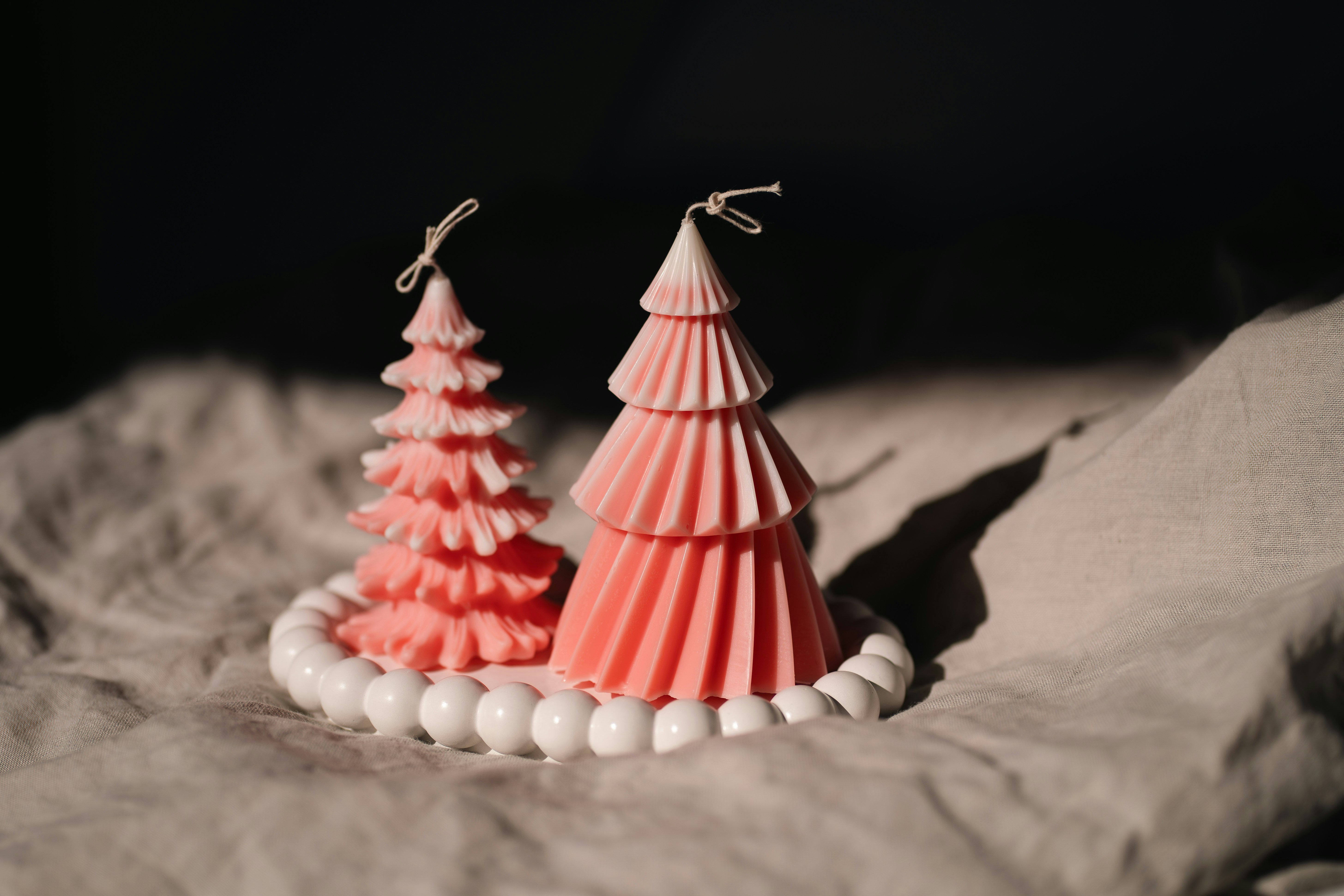 A pair of pink christmas trees sitting on top of a bed