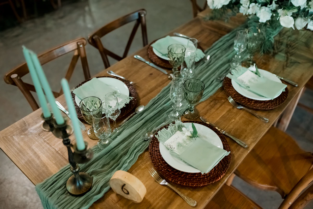A wooden table topped with lots of plates and glasses