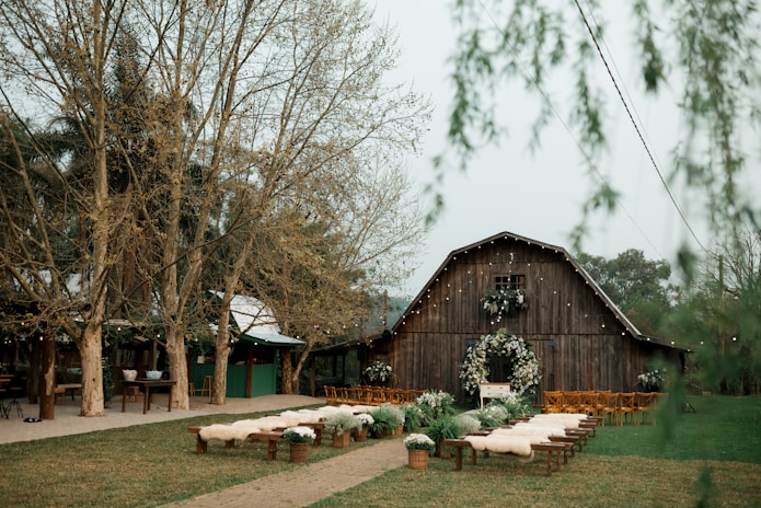 A wooden barn with benches and wreaths on it