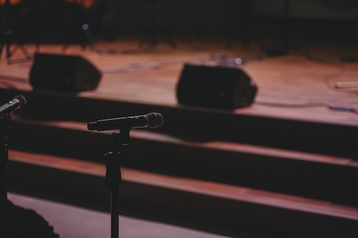 A microphone and a microphone stand in front of a stage