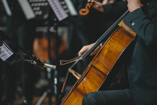 A man playing a cello in a orchestra