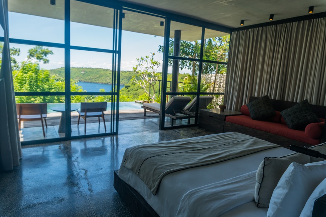 A bedroom with a large bed and a large window,
