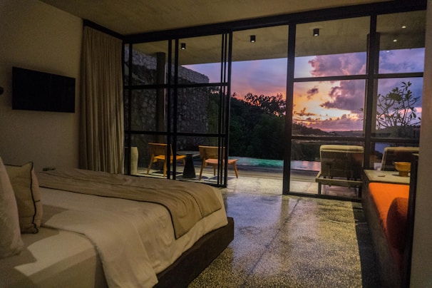 A bedroom with a bed and a large window