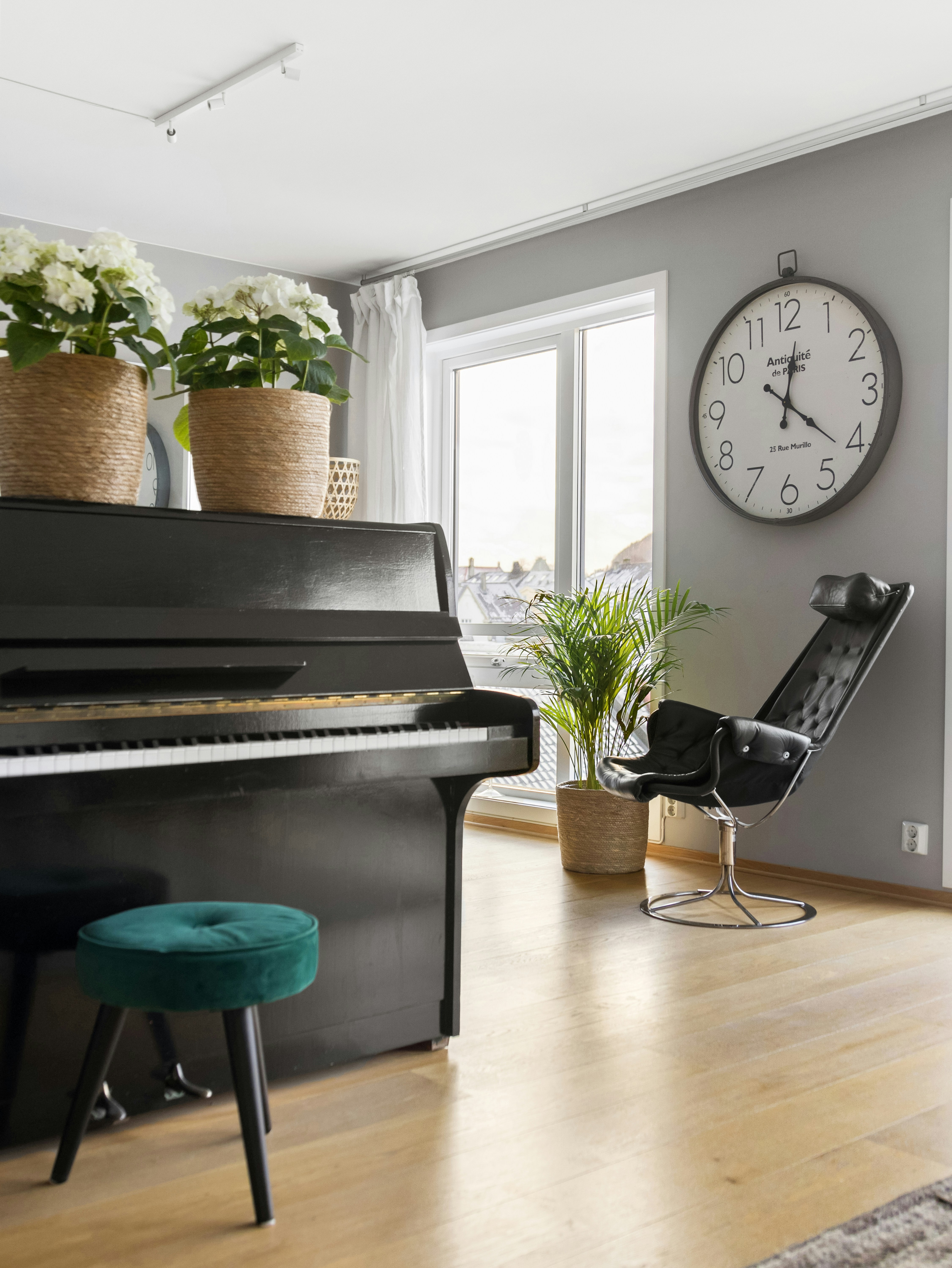 Ein Wohnzimmer mit einem Klavier und einer Uhr