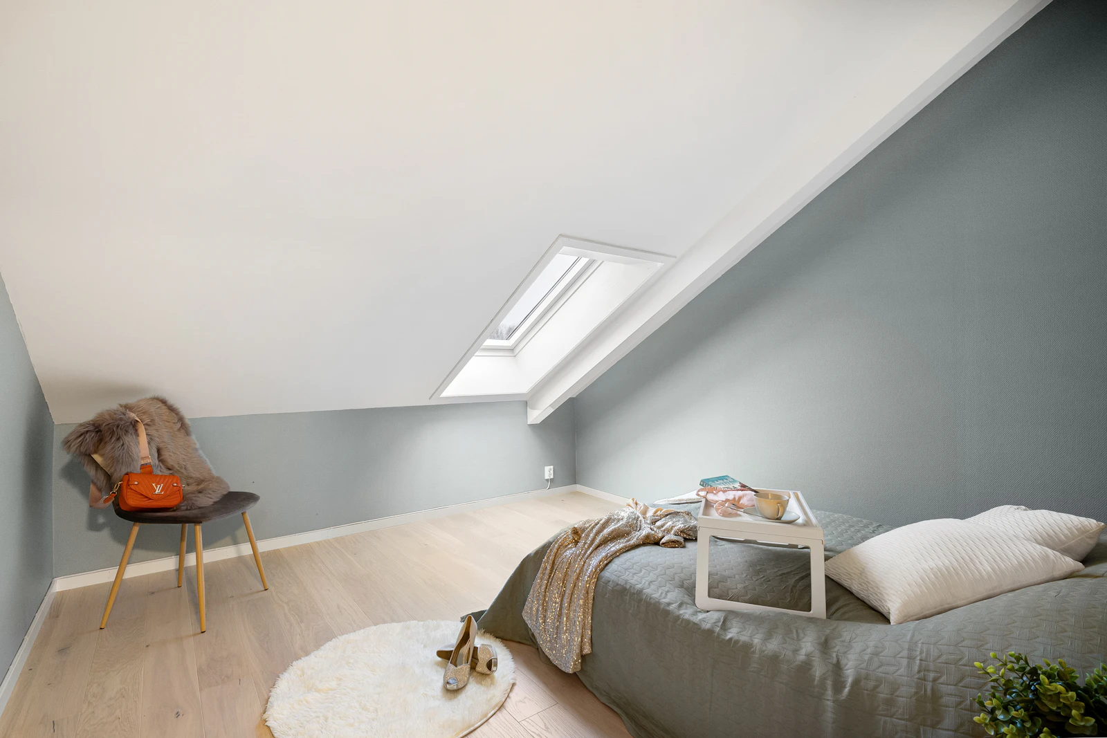 Bedroom under a sloping ceiling lit by a roof window
