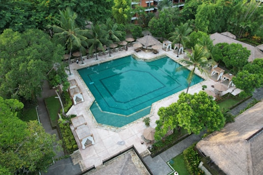 An aerial view of a resort pool surrounded by trees