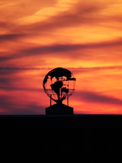 A silhouette of a windmill with the sun setting in the background