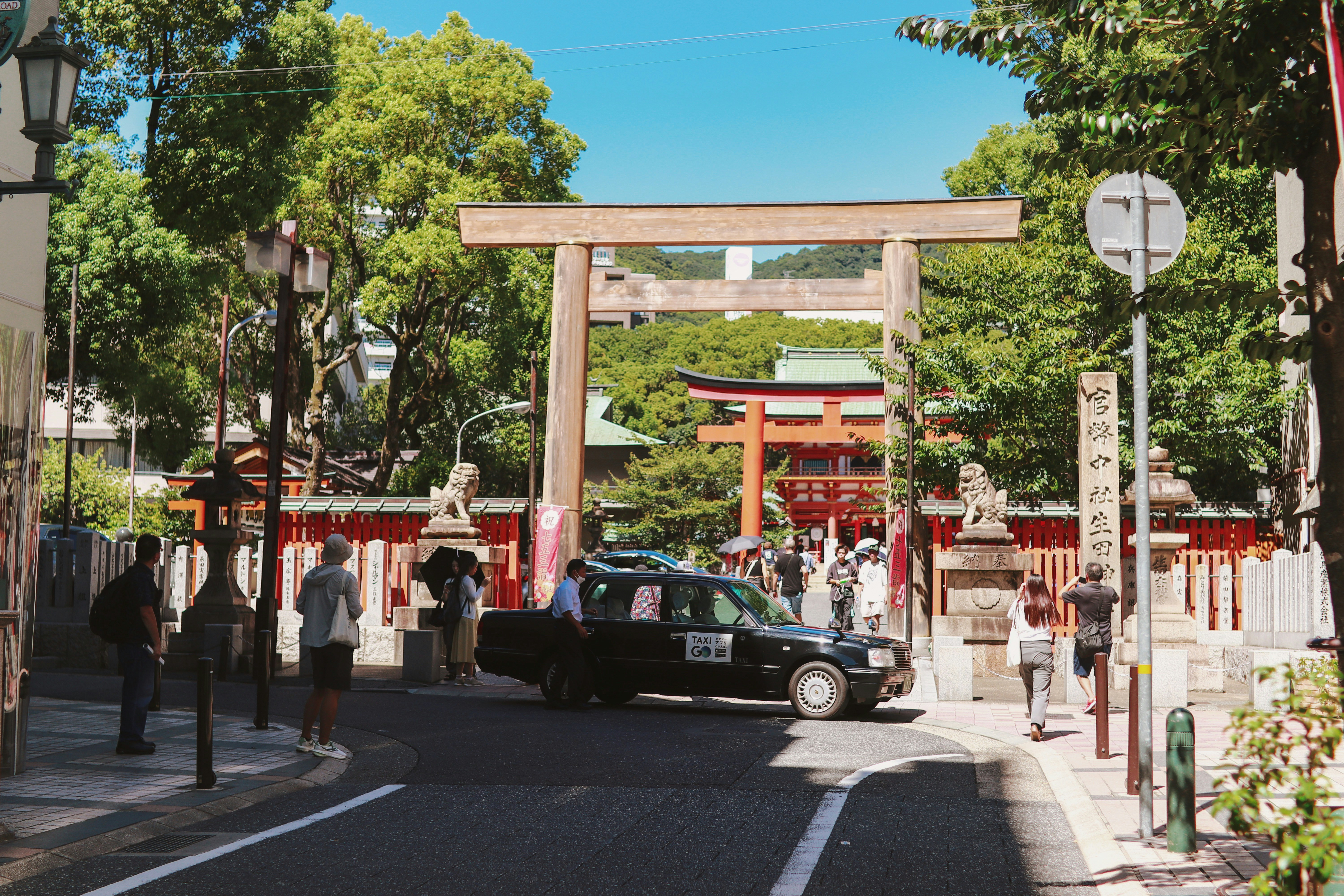 A car driving down a street next to a tall gate