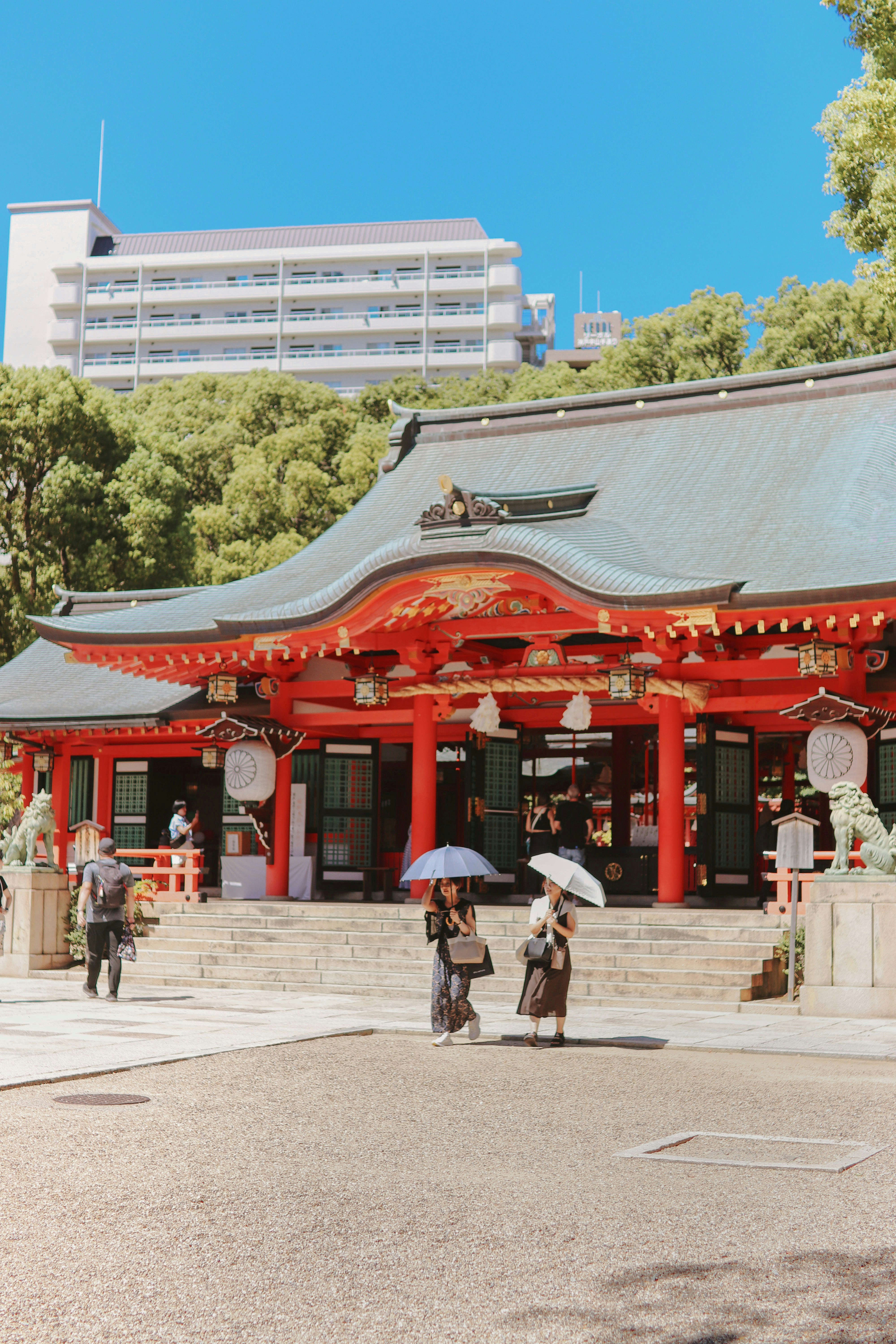建物の前に立つ傘をさした人々のグループ