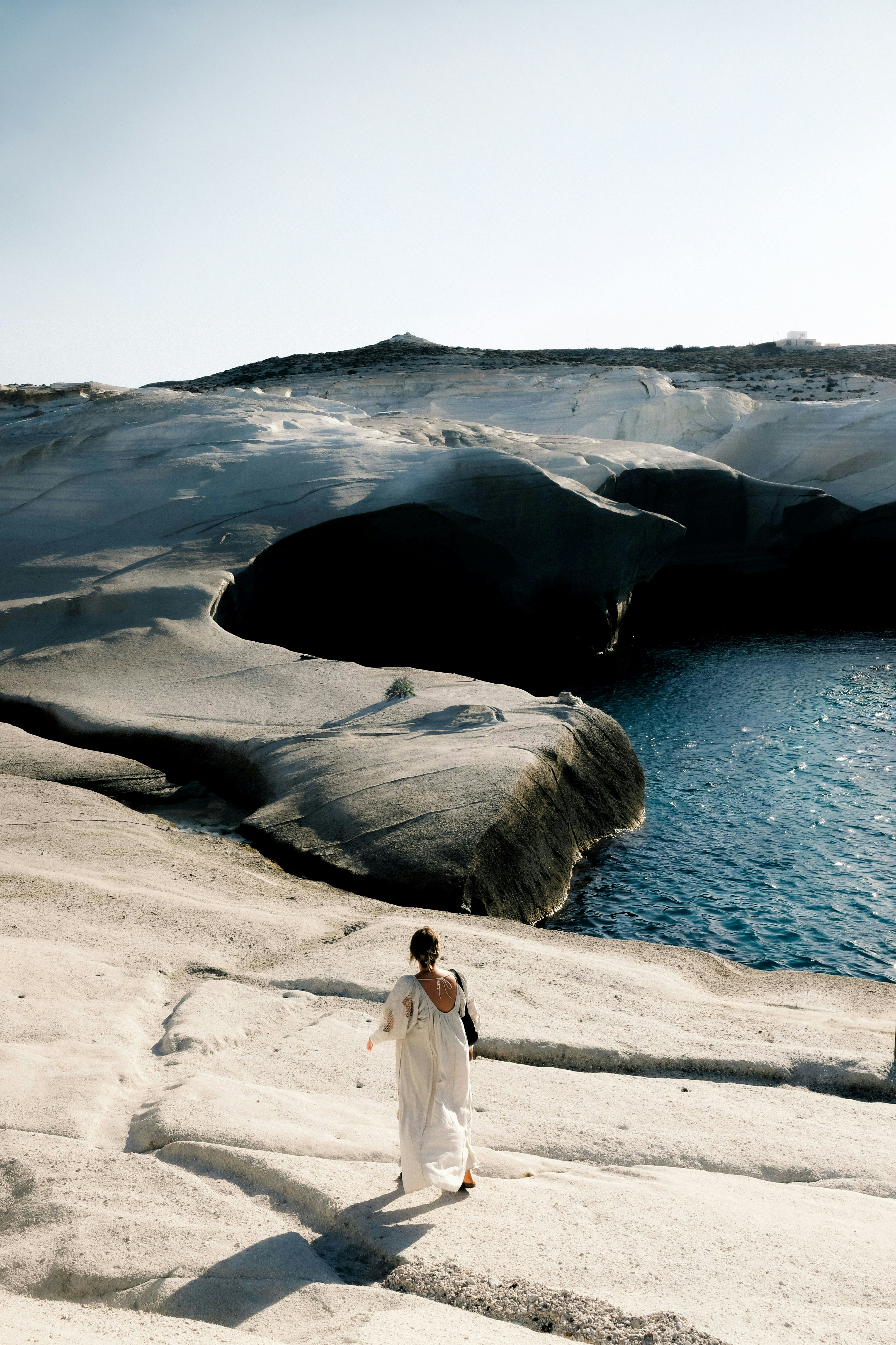 A woman in a white dress standing on a rock