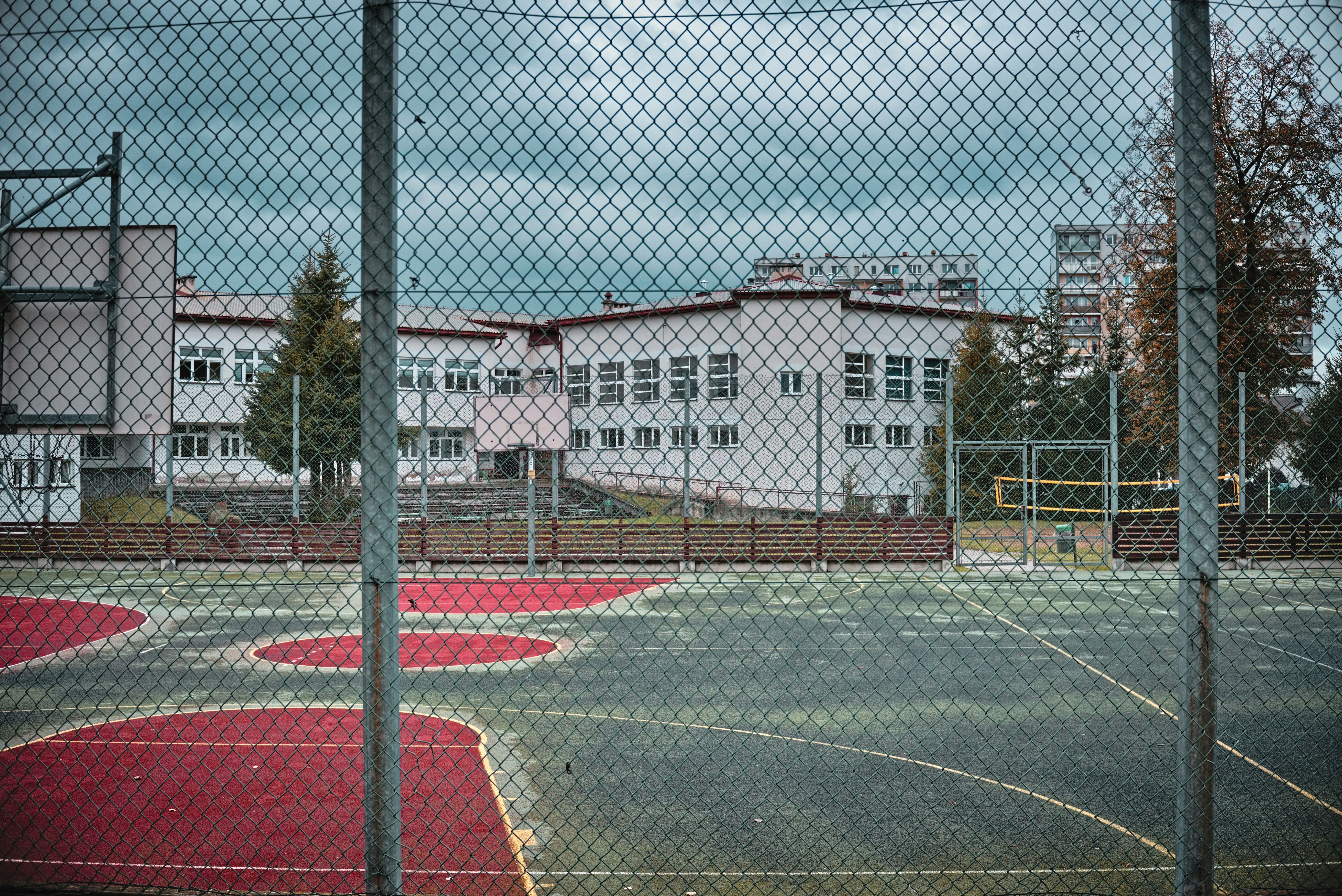 A view of a basketball court through a chain link fence