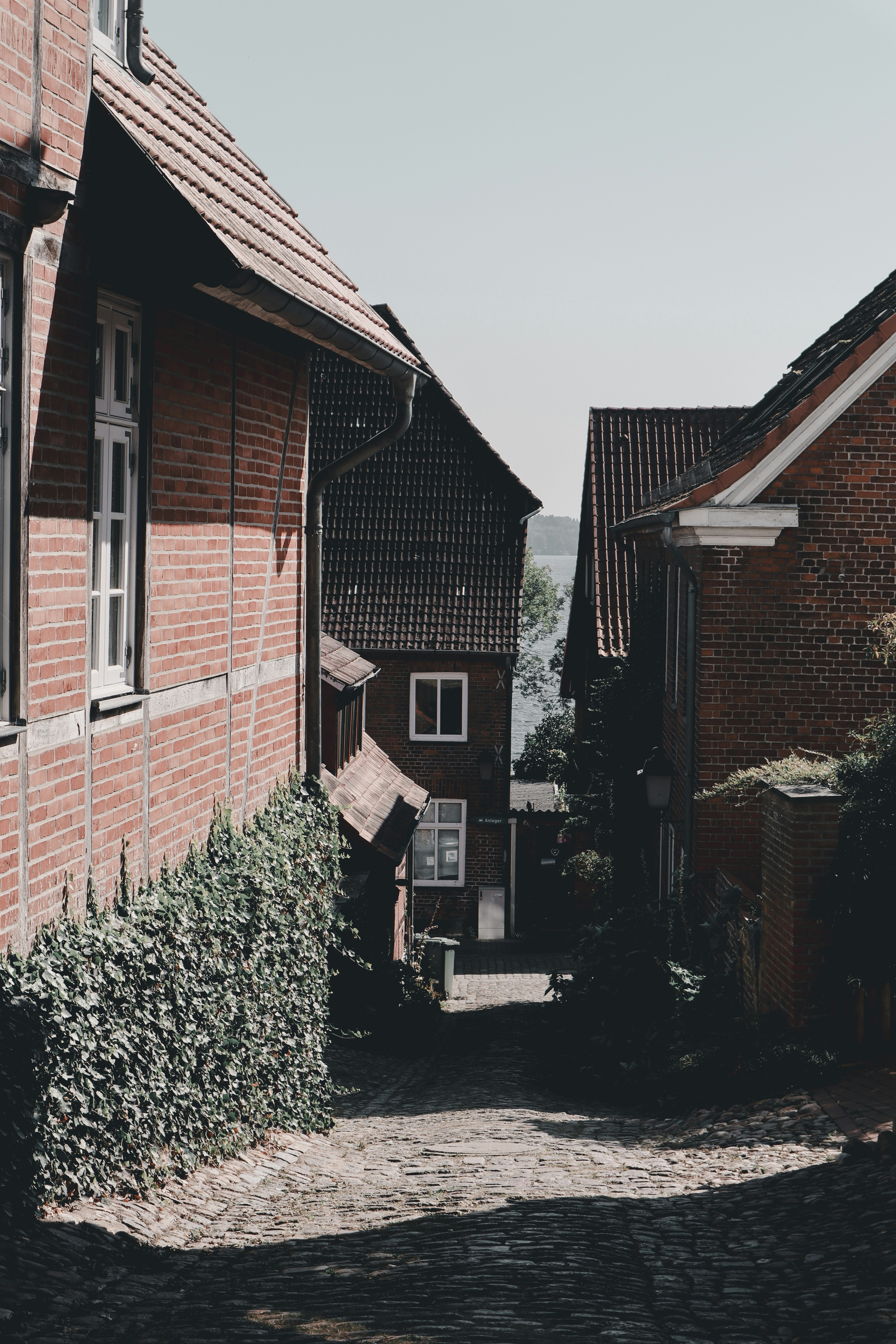 A narrow cobblestone street lined with brick buildings