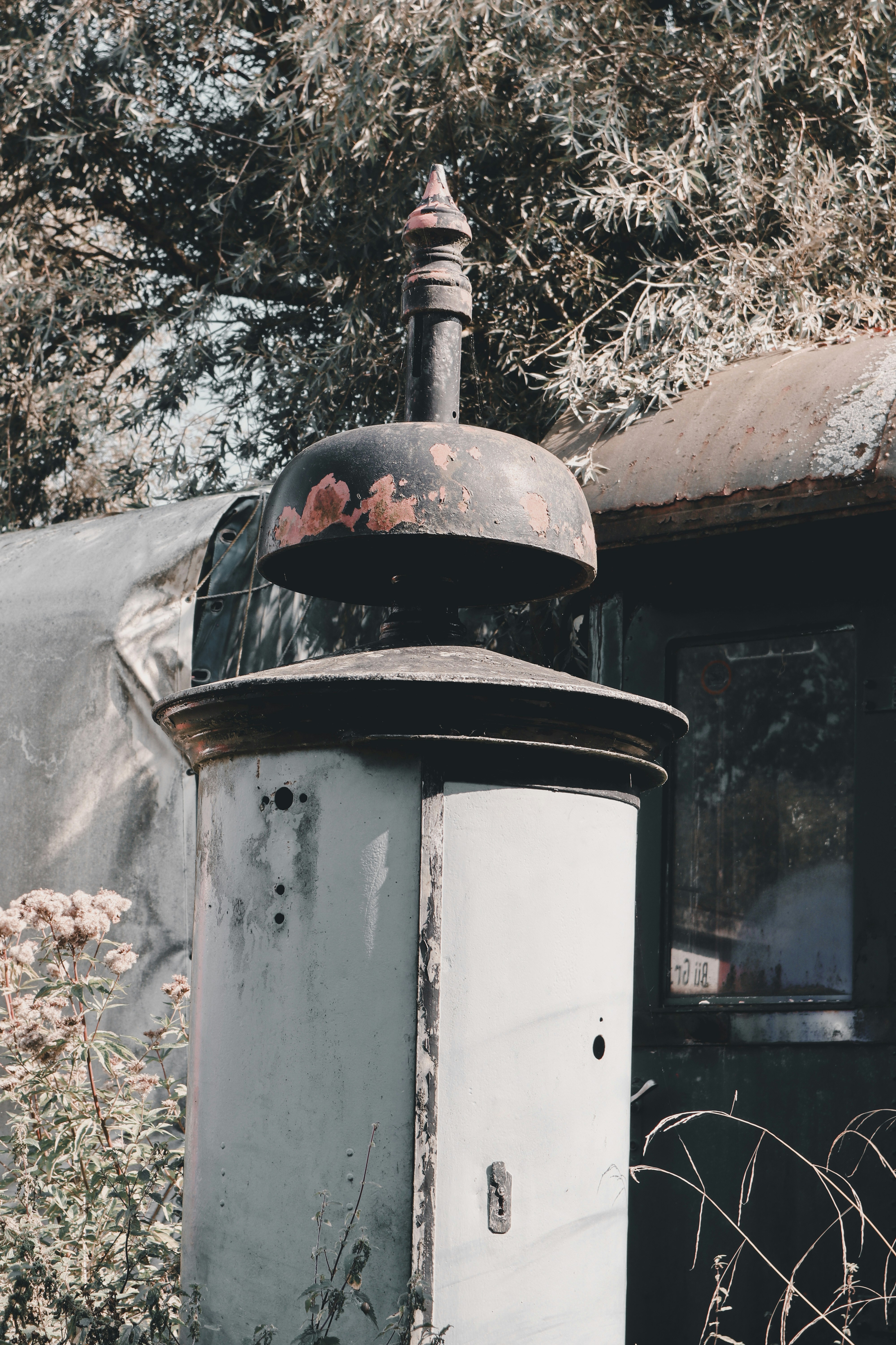 An old rusted out train car sitting in a field