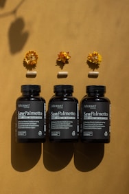 A group of three bottles of vitamins sitting on top of a table
