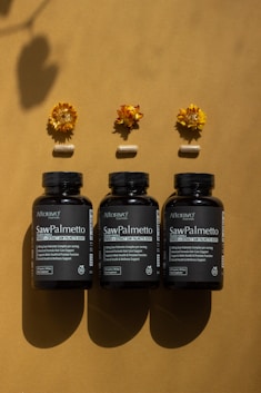 A group of three bottles of vitamins sitting on top of a table