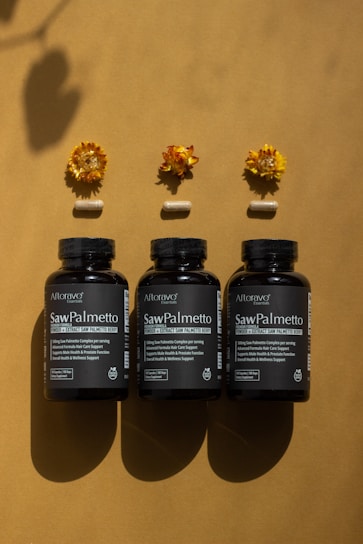 A group of three bottles of vitamins sitting on top of a table