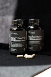 Two bottles of saw palmetto sitting on a table