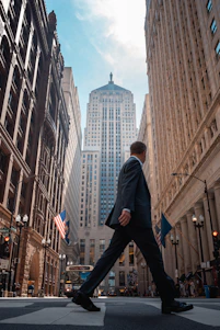 A man in a suit walking across a street