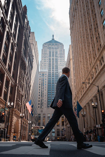 A man in a suit walking across a street