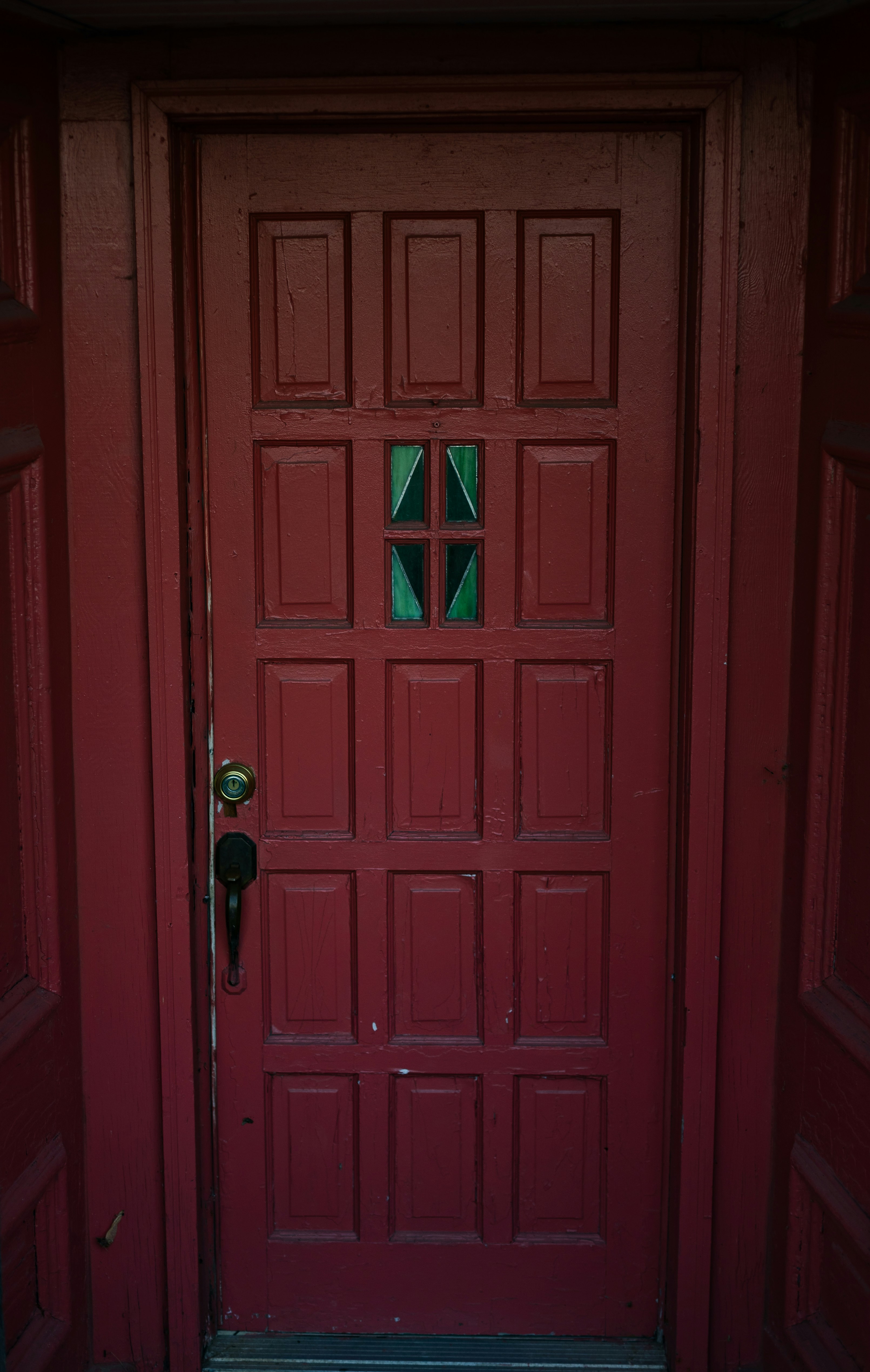A red door with a green glass window
