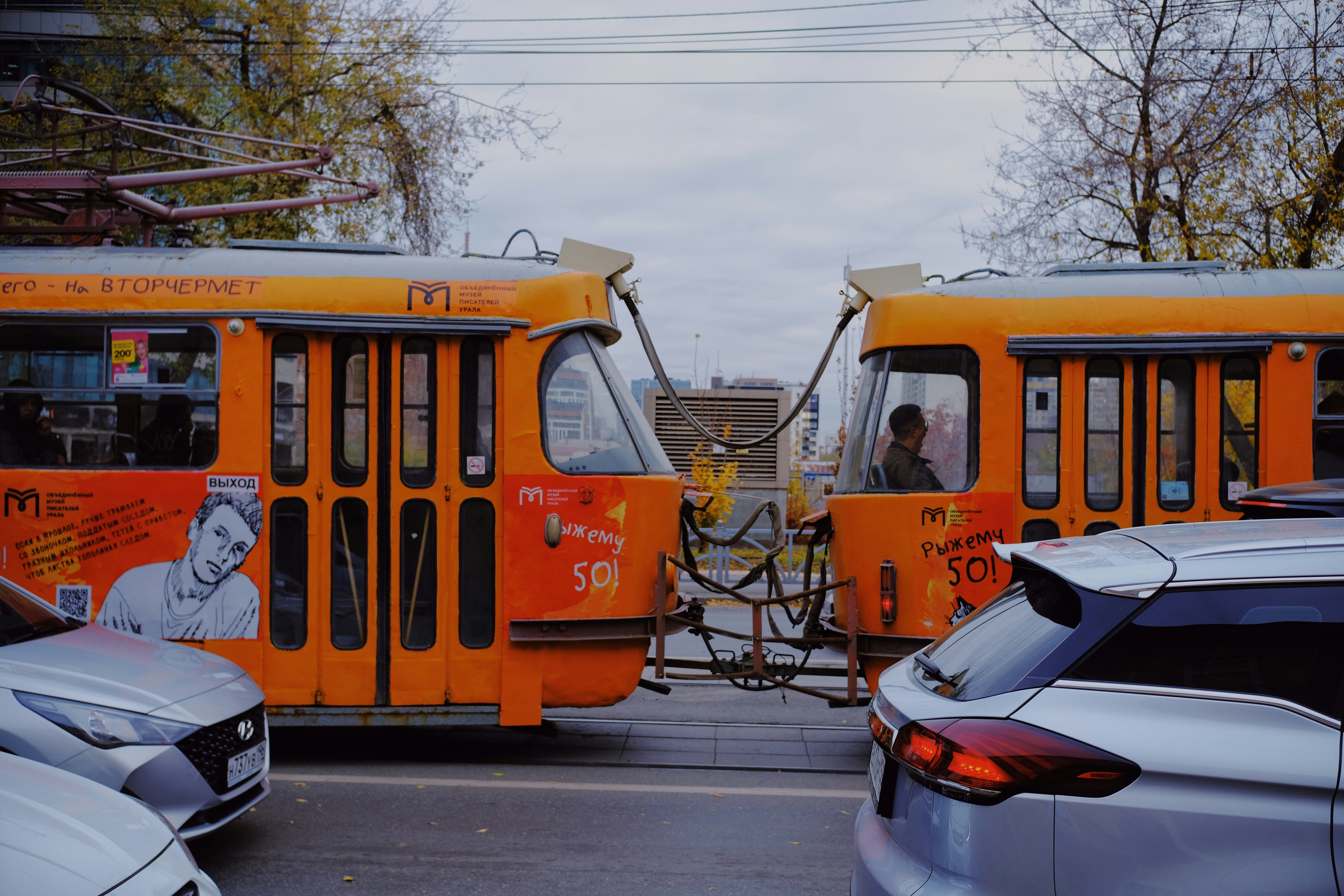 A couple of orange buses parked next to each other