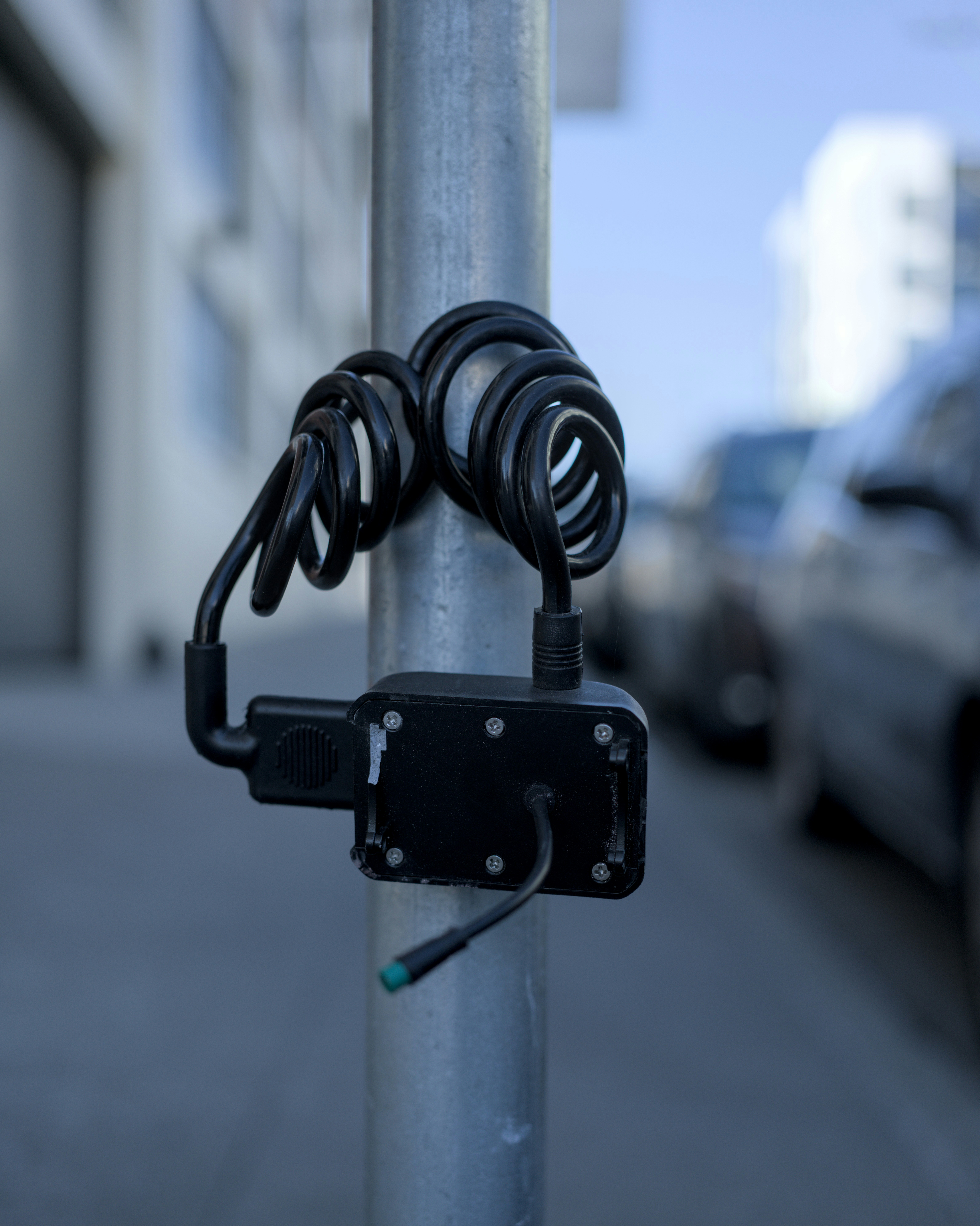 A close up of a street pole with a bunch of wires attached to it