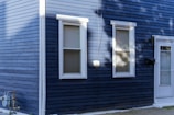 A blue house with a white door and windows
