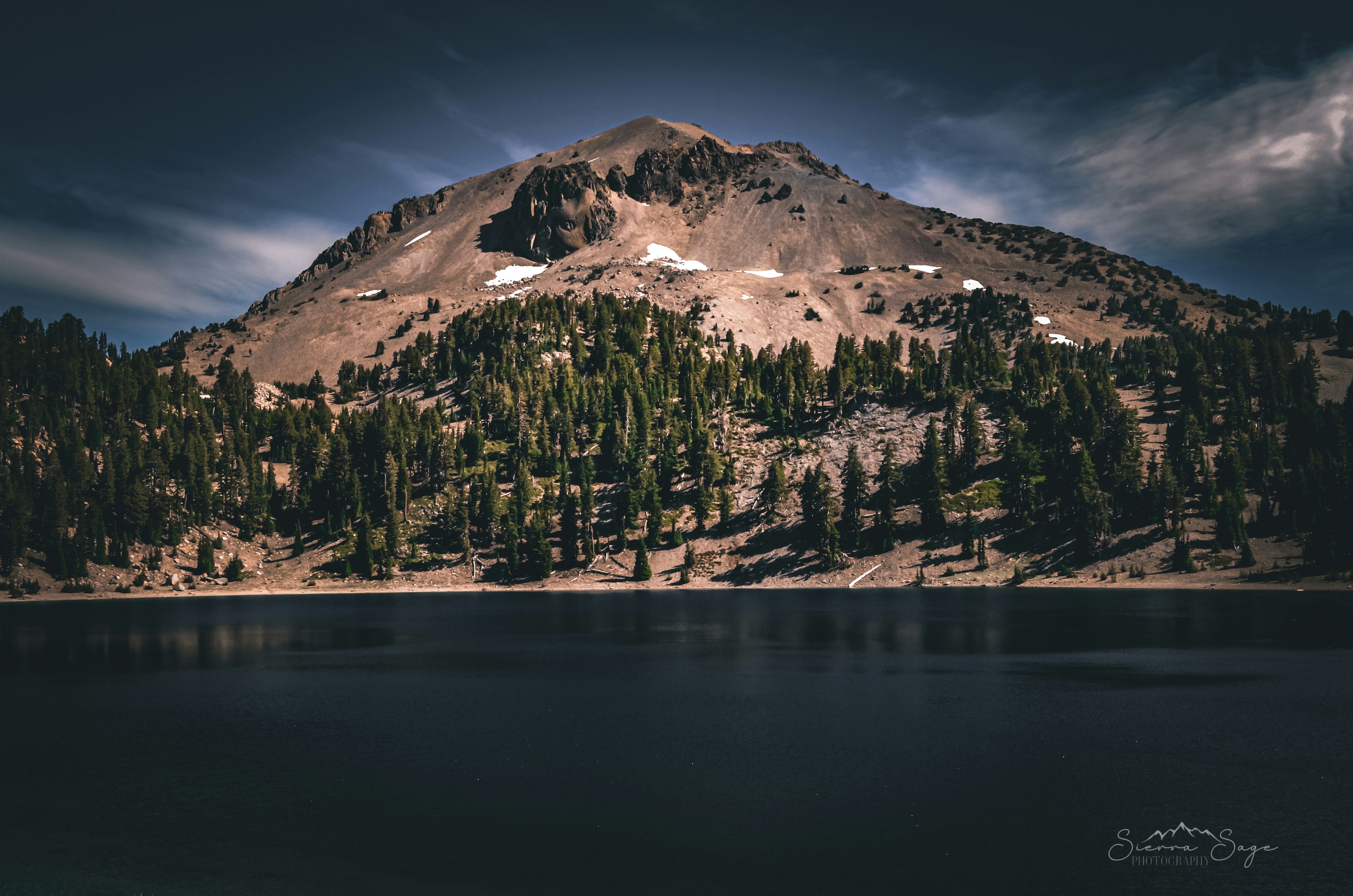 Una montaña con un lago frente a ella