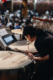 A woman playing drums in front of an audience
